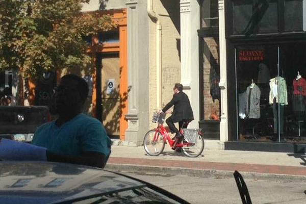 Mayor John Cranley rides a Red Bike on the sidewalk