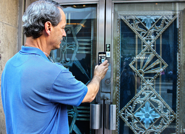 Architectural photographer J. Miles Wolf demonstrates the QR code on one of his architectural detail photographs, installed along a downtown walking route.