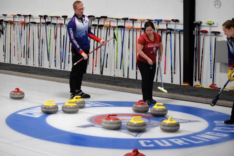 Stephanie Simpson, Amanda Smies and Josh Smies survey the stones after a shot is made to determine their next move. They were participants in the CincySpiel tournament hosted by the Cincinnati Curling Club in November 2024.