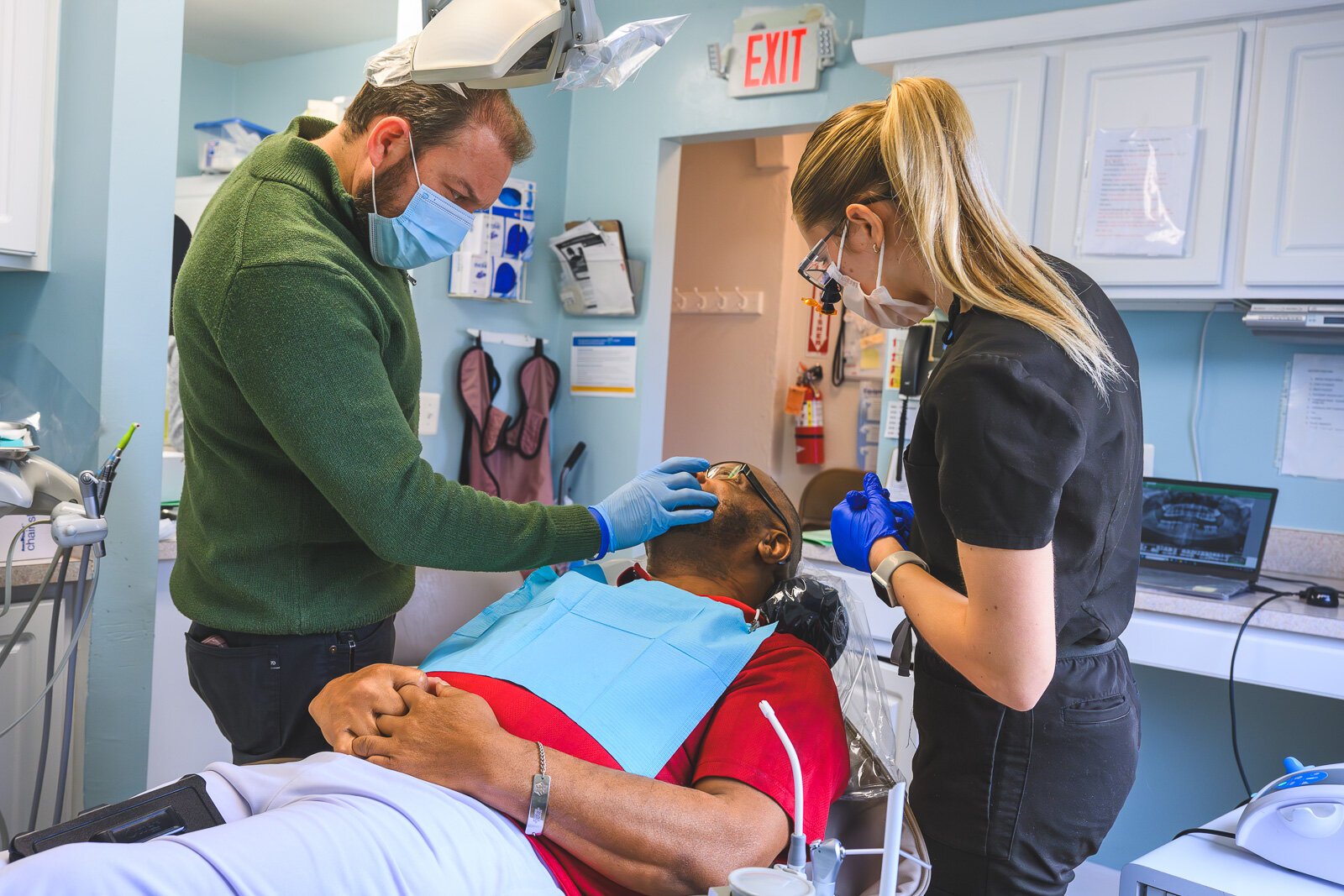 Dr. Ken Marriott, patient Thomas Jones, and dental intern Sarah Cawthon at the VINA Community Dental Clinic in Brighton.