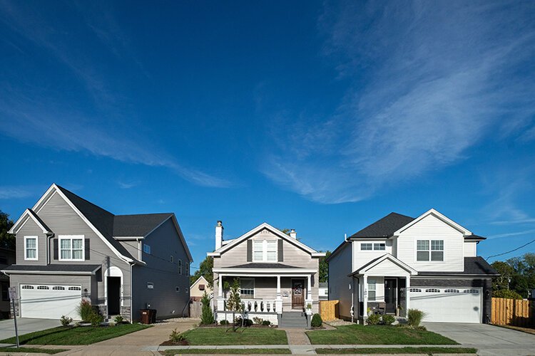 Two homes built on teardown lots on Watterson Street, one built in 2022 and one in 2023, flank a home built in 1930.