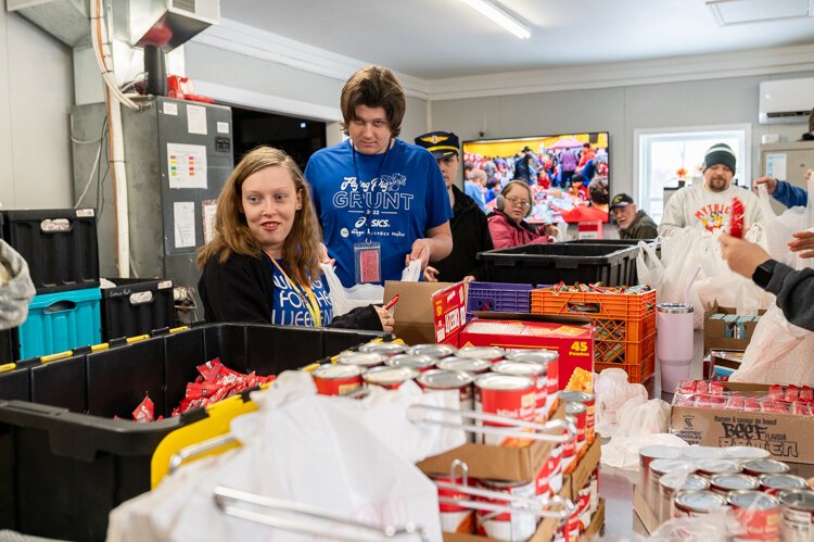 Empower Youth recruits student volunteers, some with special needs, to assemble weekend food packs.